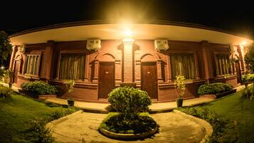 Vista frontal de la propiedad por la tarde o noche