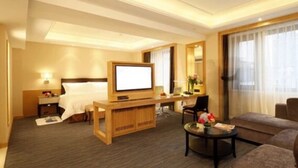 A hotel room with a bed, a desk, a television, a sofa, and a coffee table. - Yiho Hotel Bamin Fuzhou (Fuzhou)