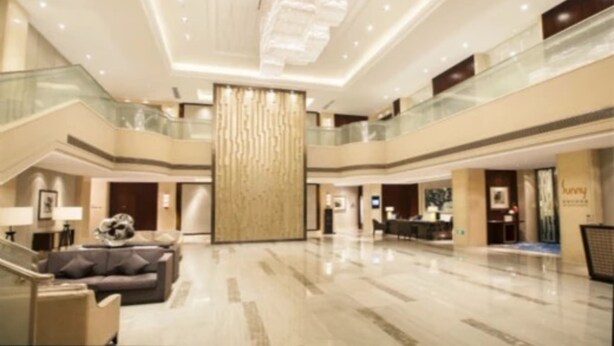 A spacious lobby with a high ceiling, a central column, and a staircase leading to an upper level. - Yiho Hotel Bamin Fuzhou (Fuzhou)