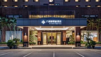 A hotel entrance with a modern design, featuring a prominent sign with the hotel's name.