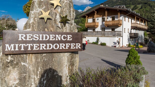 A sign for Residence Mitterdorfer with a mountain backdrop.