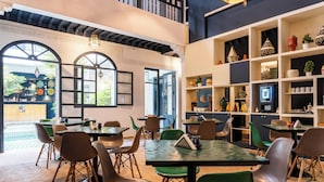 Un restaurante con mesas y sillas, y estanterías decorativas.