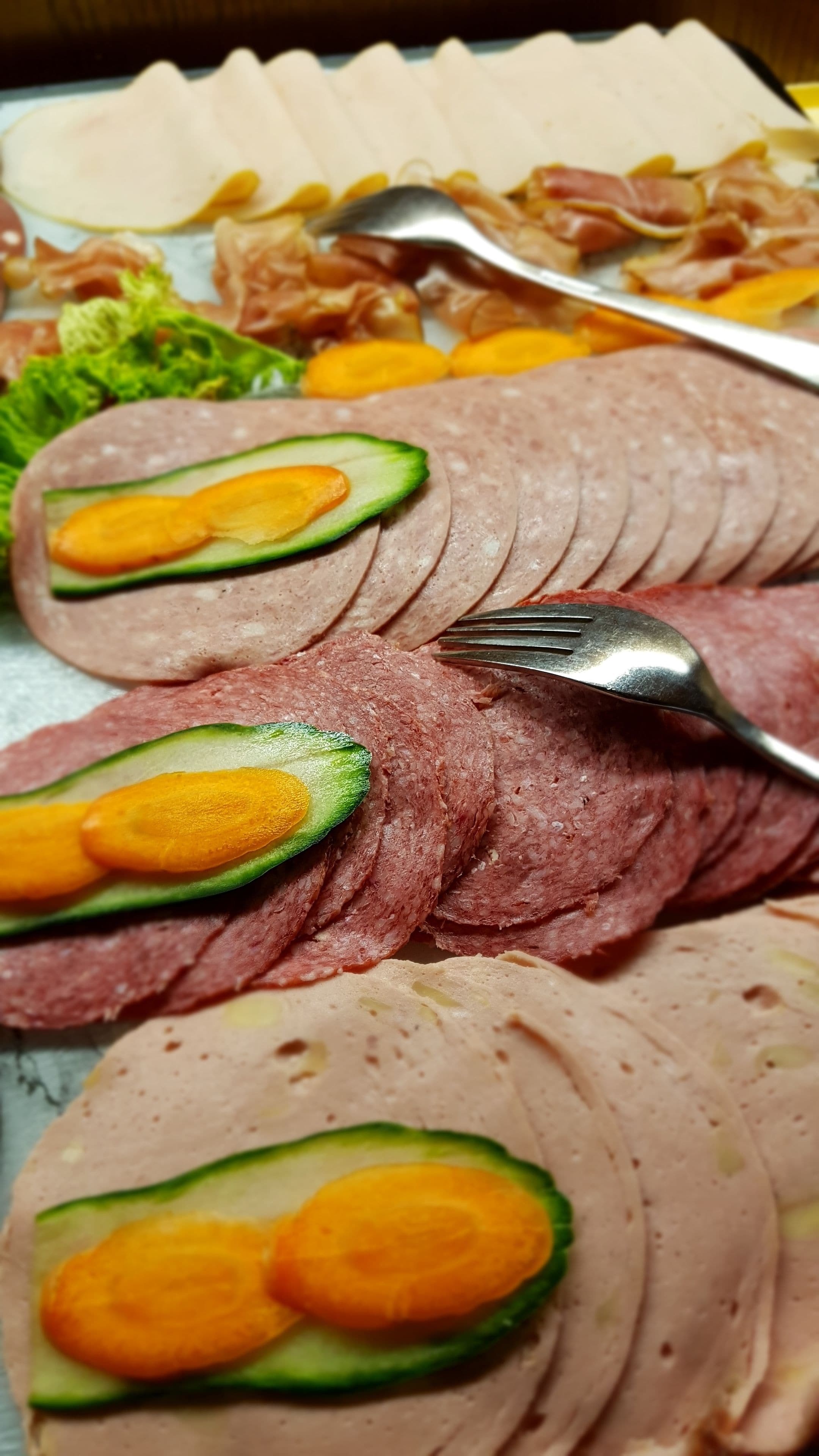 Una bandeja de carne en rodajas con rebanadas de aguacate encima.