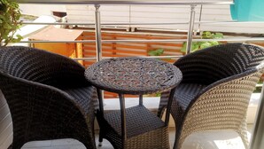 A balcony with wicker furniture, including two chairs and a small table. - Heybeli Butik Hotel (Adalar)