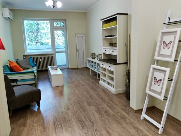 Una sala de estar con sofá, mesa de centro y estantería blanca con espacio de almacenamiento.
