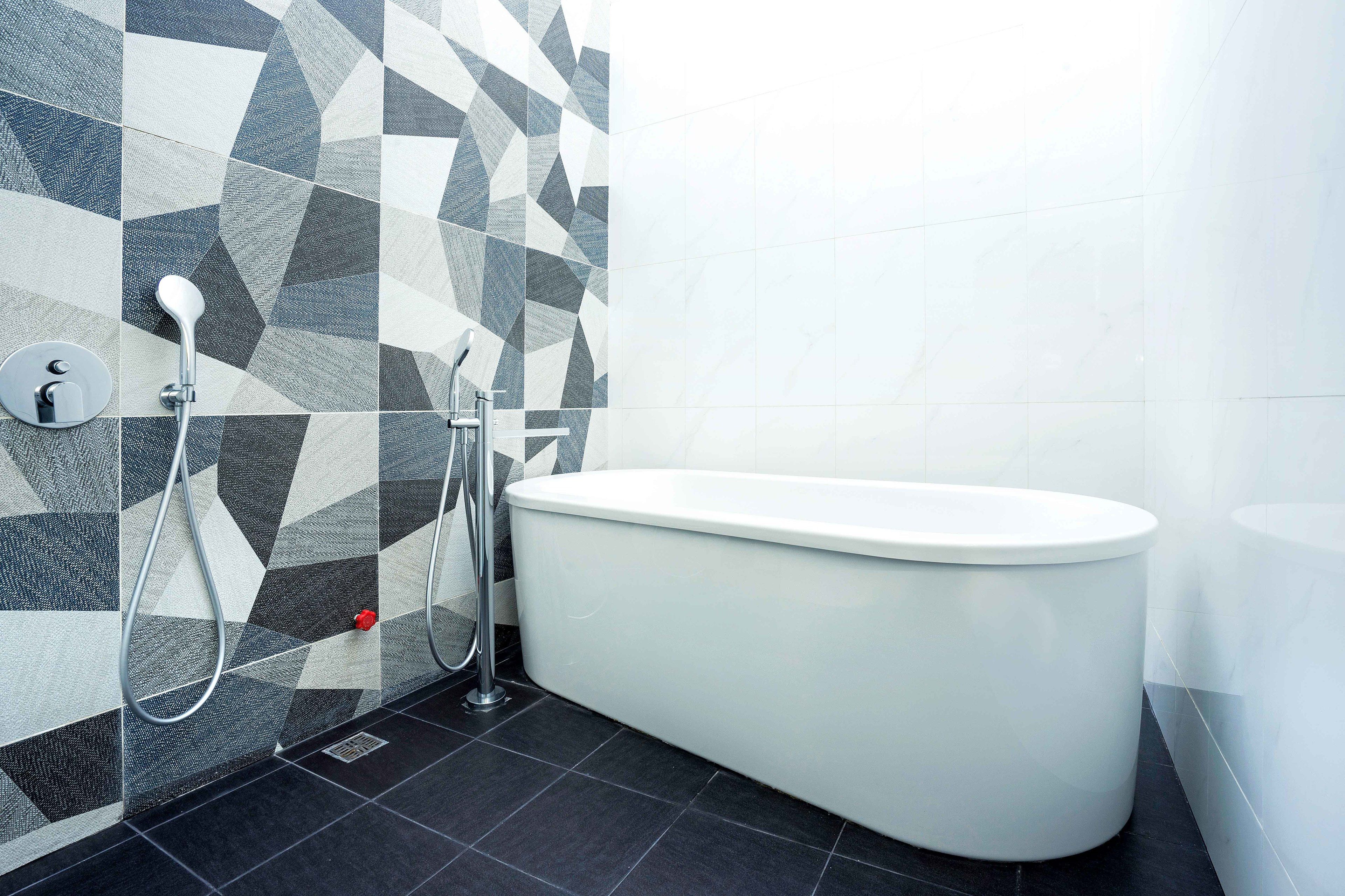 A modern bathroom with a freestanding bathtub, a showerhead, and a hand shower.
