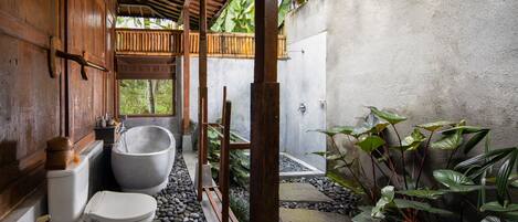 A bathroom with a wooden exterior, a large bathtub, and a toilet.