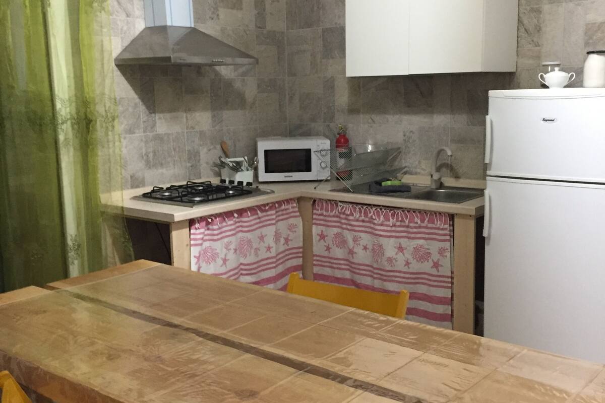 Refrigerador em uma área comum, micro-ondas em uma área comum, cooktop