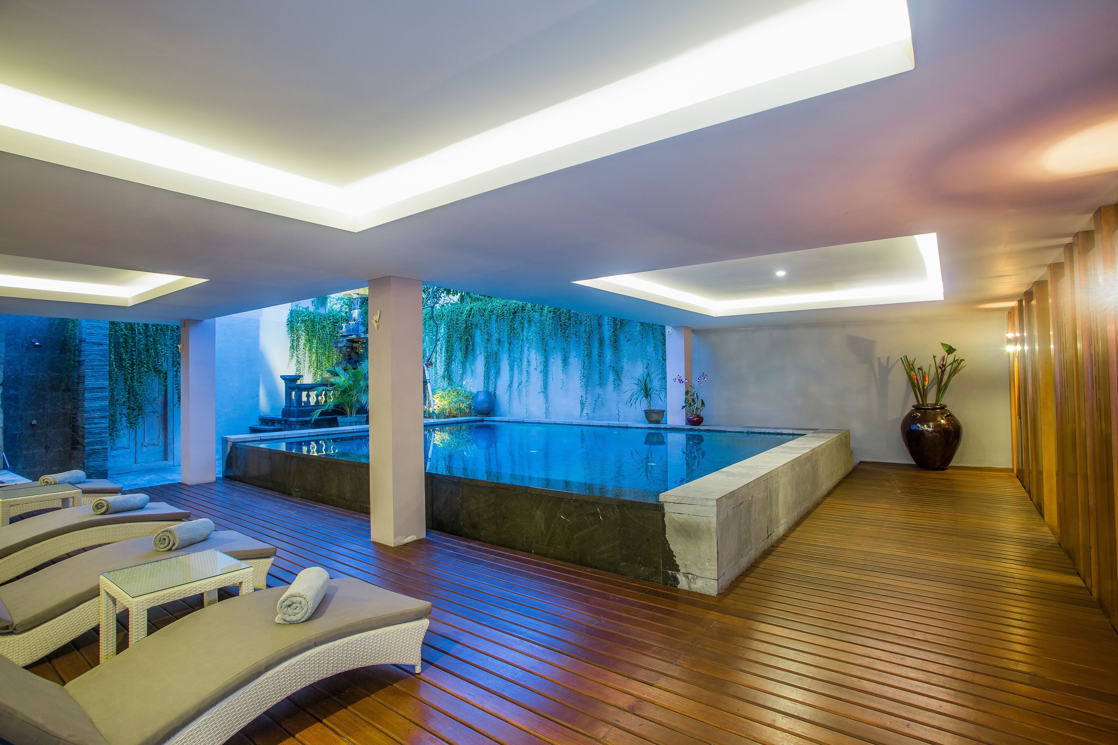 Una piscina al aire libre, sillones reclinables de piscina
