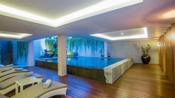 Una piscina al aire libre, sillones reclinables de piscina