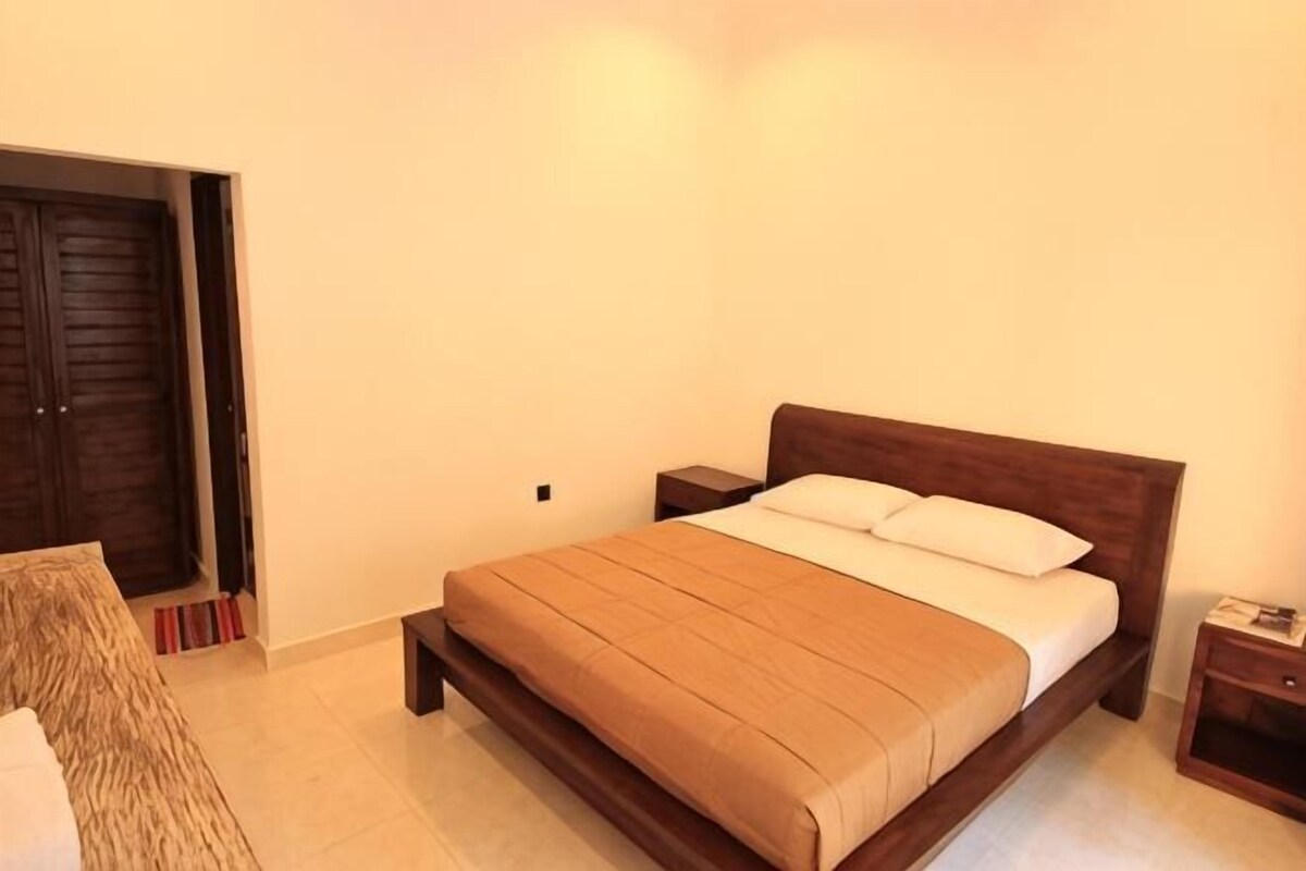Ein Schlafzimmer mit Bett, Nachttisch und Kleiderschrank.