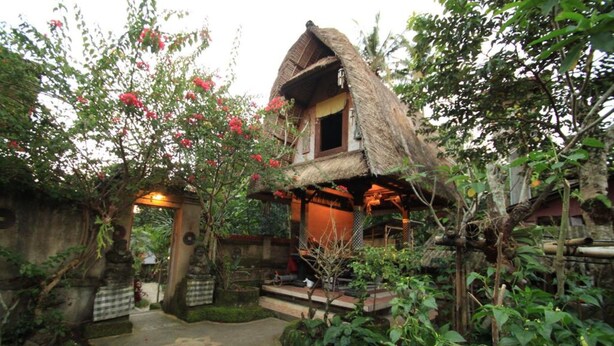 Une maison traditionnelle à toit de chaume, avec un sentier de jardin menant à l’entrée.