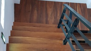 A wooden staircase with a metal handrail. - Coffee Station Hostel (Udon Thani)