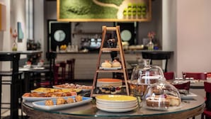 Ein Buffet mit verschiedenen Gebäcken und Desserts, eine Holzladdertreppe als Präsentation und ein großes Bild an der Wand.