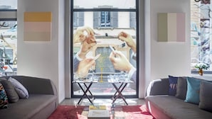 Ein modernes Wohnzimmer mit einem großen Fenster, zwei Sofas, einem Couchtisch und Blick auf die Straße.