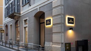 Ein Gebäude mit mehreren Fenstern und einem Balkon, mit beleuchteten Schildern für "Sofitel" und "Garden Inn".