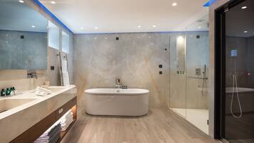Un baño moderno con una bañera grande, un tocador con espejo y una cabina de ducha de vidrio.