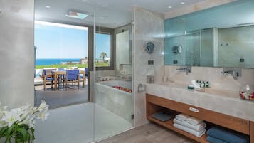 A modern bathroom with a large mirror, a hair dryer, and a view of the ocean.