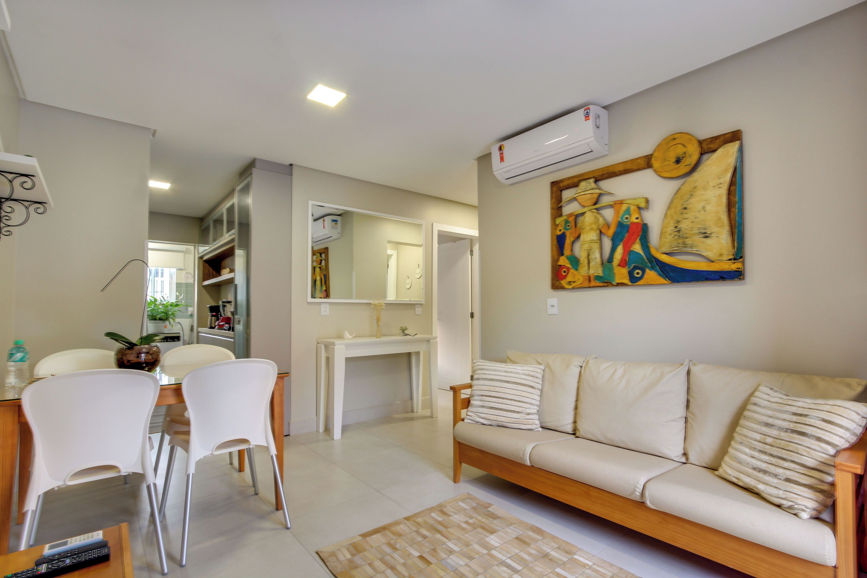 A living room with a sofa, chairs, a coffee table, and a painting on the wall.