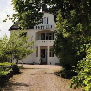 A white building with a sign that reads 'HOTELL' at the top.