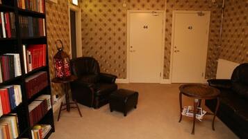 A room with a leather armchair, a small ottoman, a bookshelf, and two doors labeled 44 and 43.