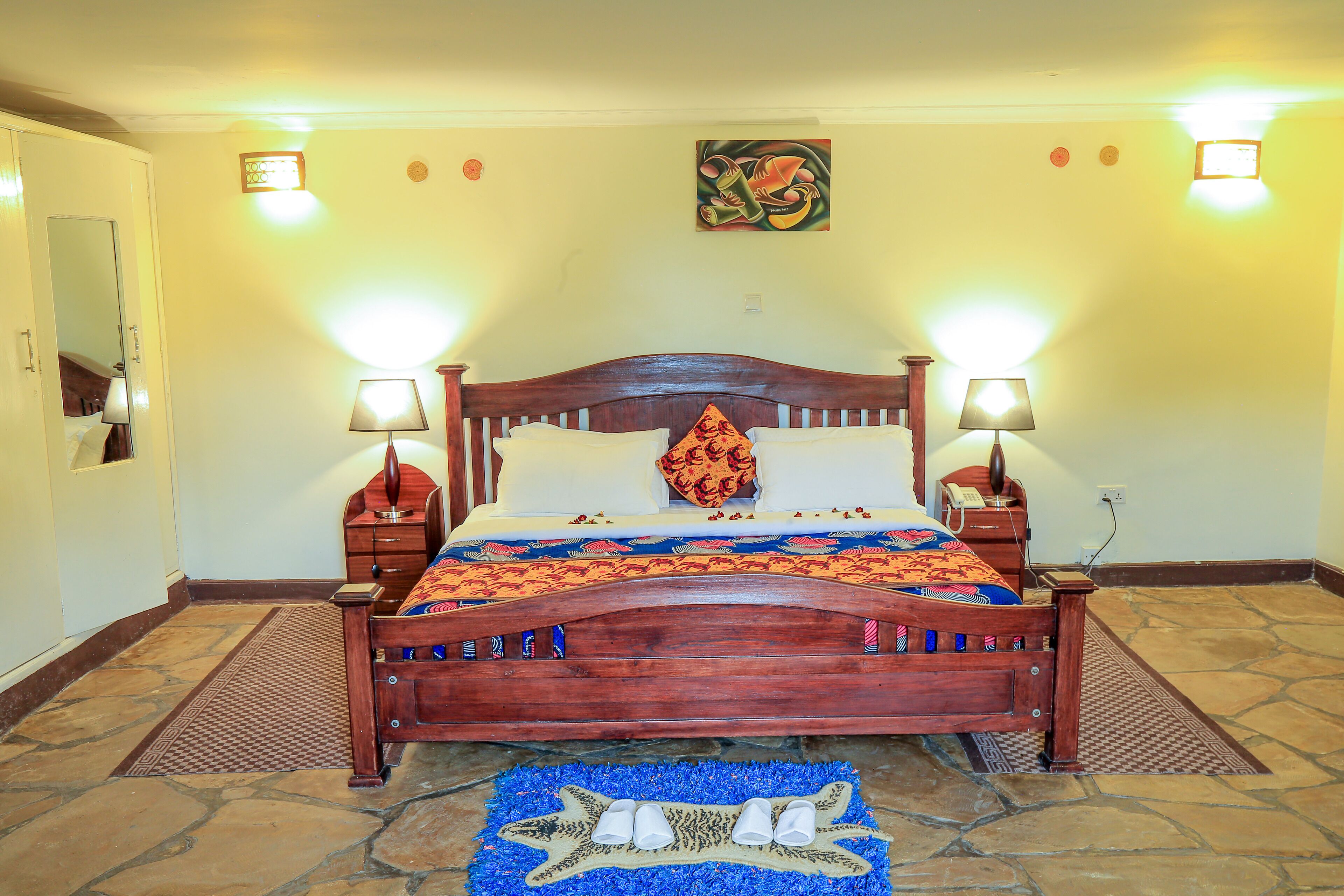 A wooden bed with two bedside tables, a patterned bedspread, and a decorative pillow.