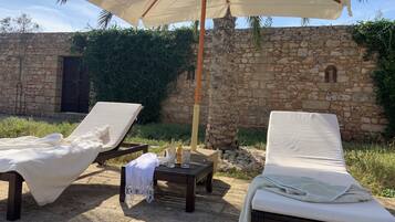 Una piscina al aire libre, sillones reclinables de piscina
