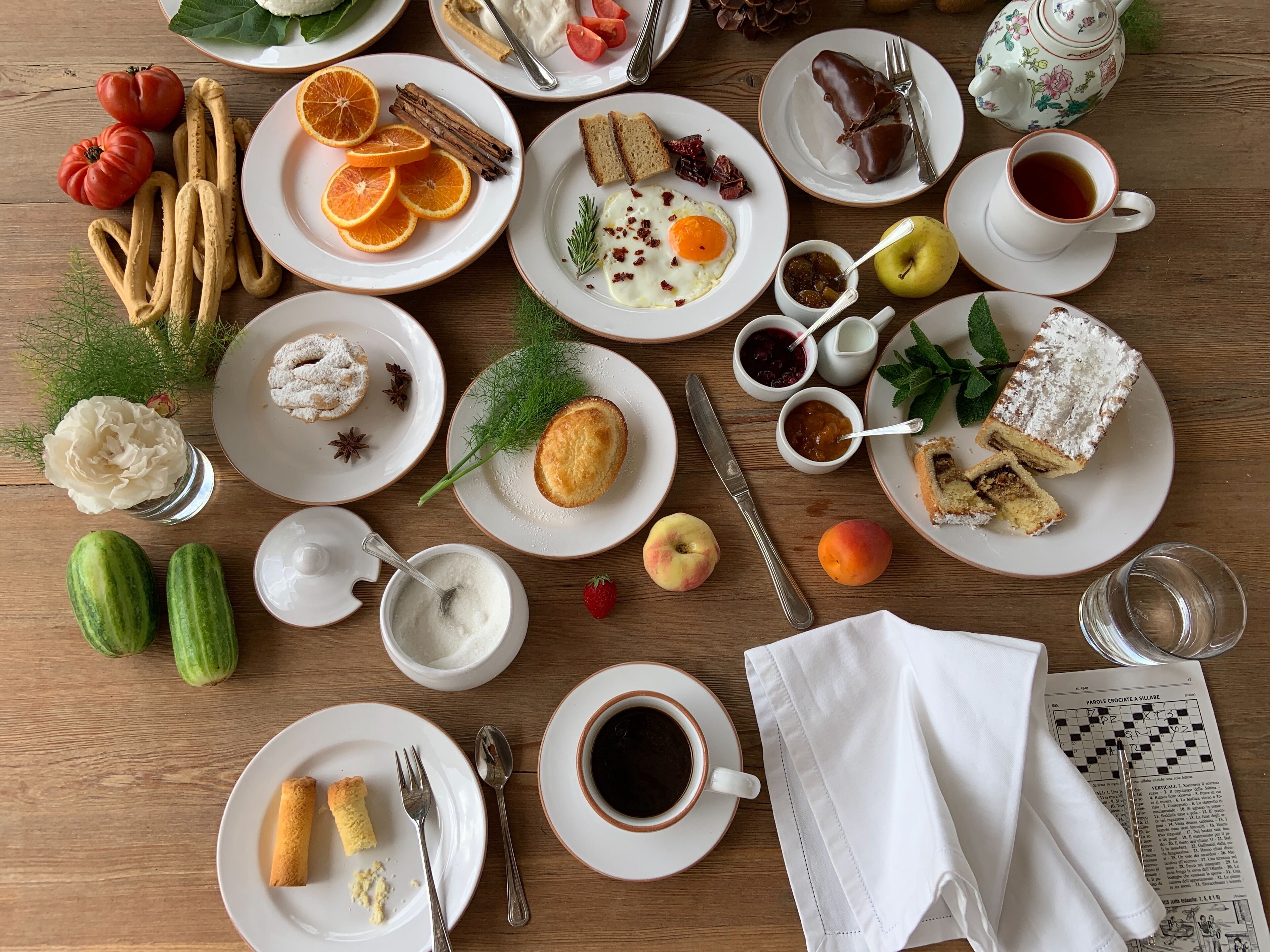A table with various breakfast items including pastries, fruits, and beverages.
