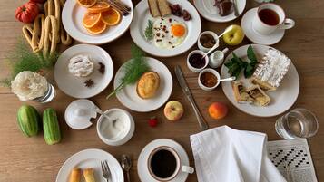 A table with various breakfast items including pastries, fruits, and beverages.