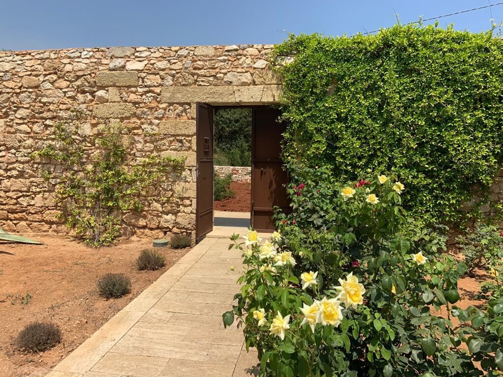 A stone building with a wooden door and a paved pathway leading to it.