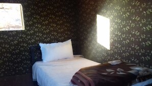 A room with a bed, a window, and floral wallpaper. - Wadi Rum Accommodation Tour (Wadi Rum)