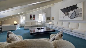 A modern living room with a glass coffee table, white sofas, and a large abstract painting on the wall. - ARNOLDI-Rooftop (Venice)