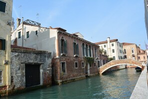 A canal with a bridge and buildings along the water. - ARNOLDI-Rooftop (Venice)
