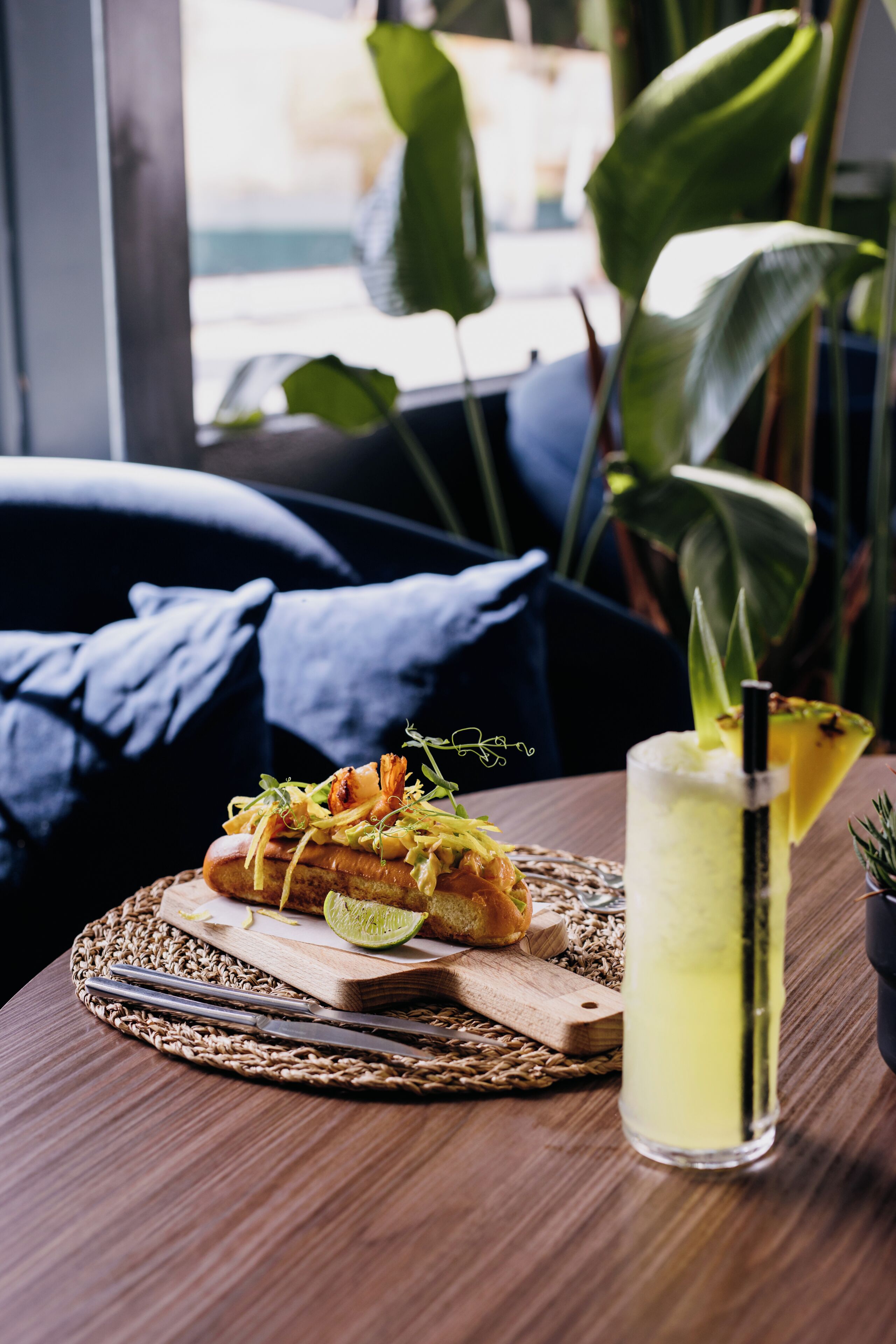 A table with a meal, a drink, and a plant.