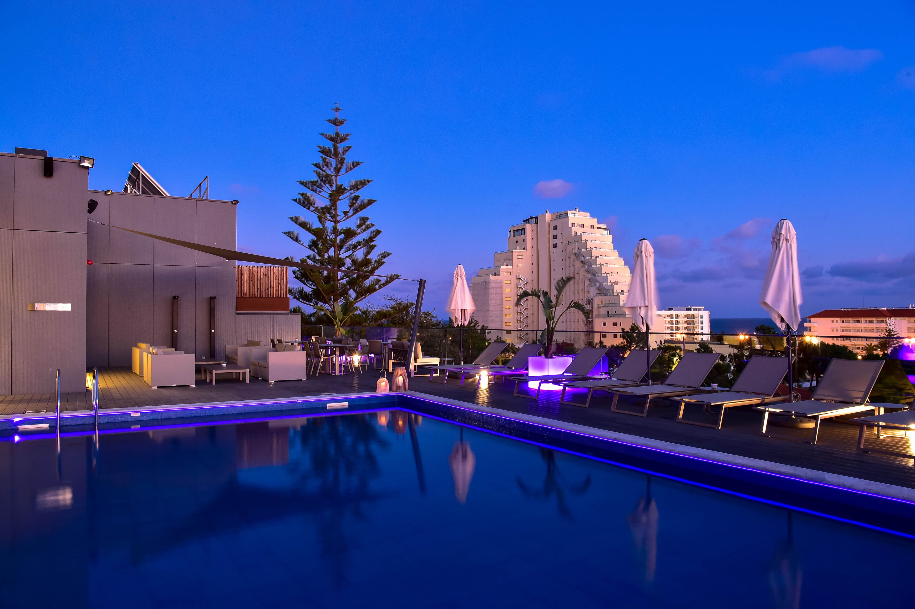 Una piscina cubierta, una piscina al aire libre, sombrillas, tumbonas