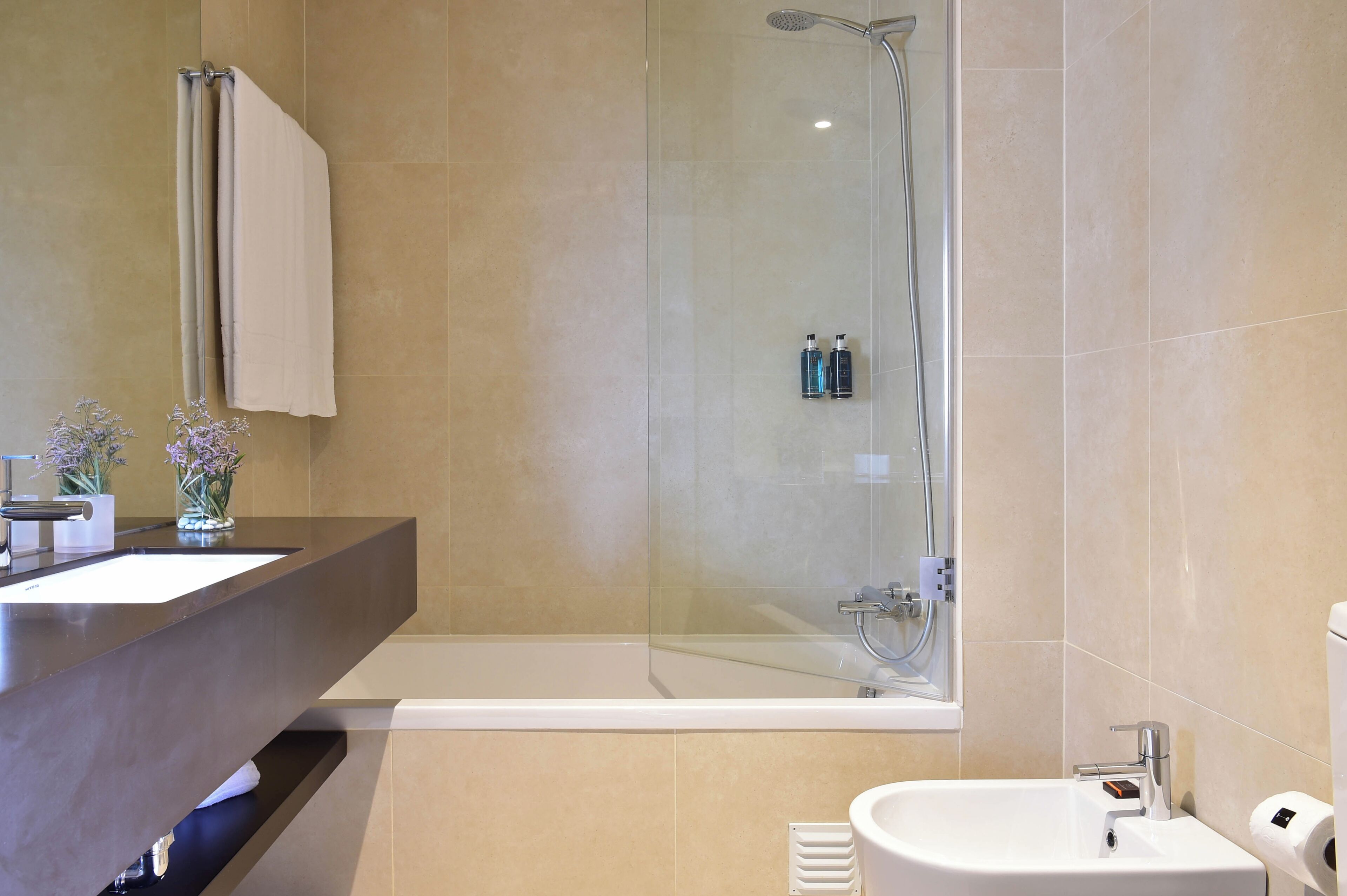 Ein modernes Badezimmer mit einer Duschkabine, einem Waschtisch und einer Toilette.