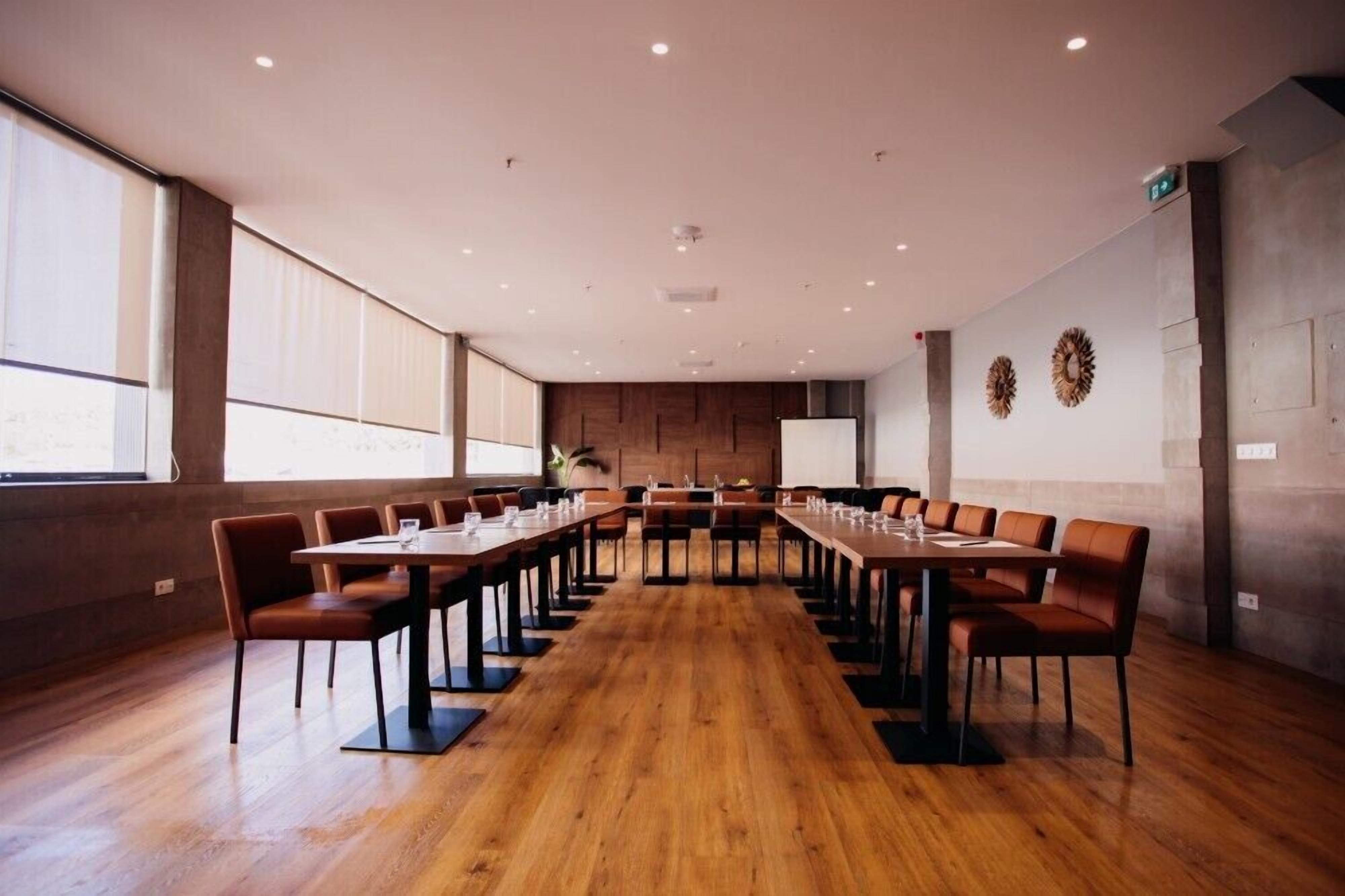 A conference room with long tables, chairs, and a whiteboard.