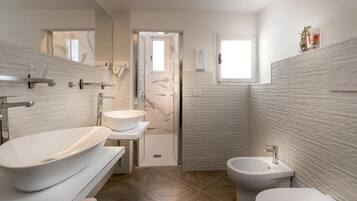 Deluxe studio | Badkamer | Een douche, gratis toiletartikelen, een haardroger, pantoffels