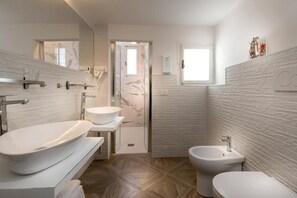 Deluxe-studiolejlighed | Badeværelse | Bruser, gratis toiletartikler, hårtørrer, hjemmesko
