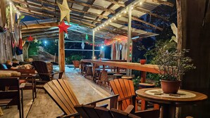 An outdoor patio with wooden furniture, string lights, and star decorations.