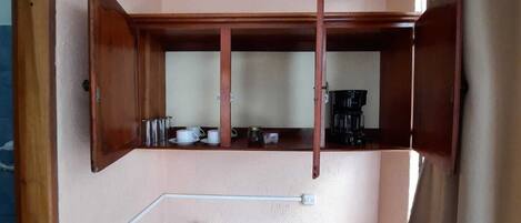 Una cocina pequeña con un lavamanos, armarios de madera y una encimera.