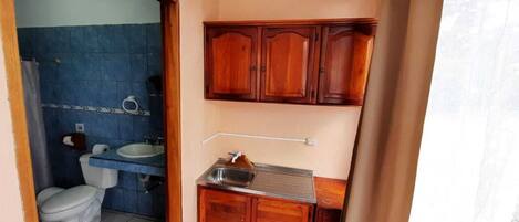 Une petite salle de bain comprenant des toilettes, un lavabo et des meubles en bois.