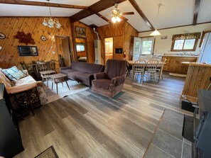 A cozy cabin interior with a living room, dining area, and kitchen. - Grandpa Jim's Cabin (Montreal)