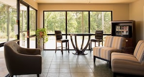 Una habitación amplia con un gran ventanal, una mesa de comedor, sillas, un sofá y un televisor.