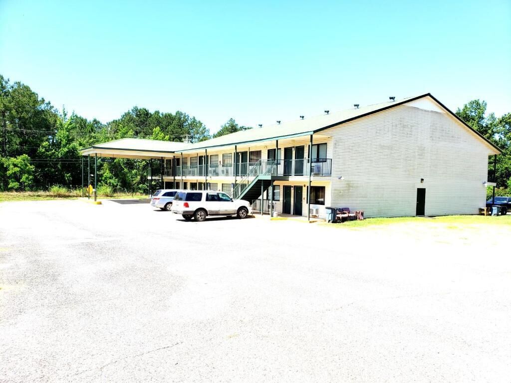 A two-story building with a covered parking area and a single-story annex.