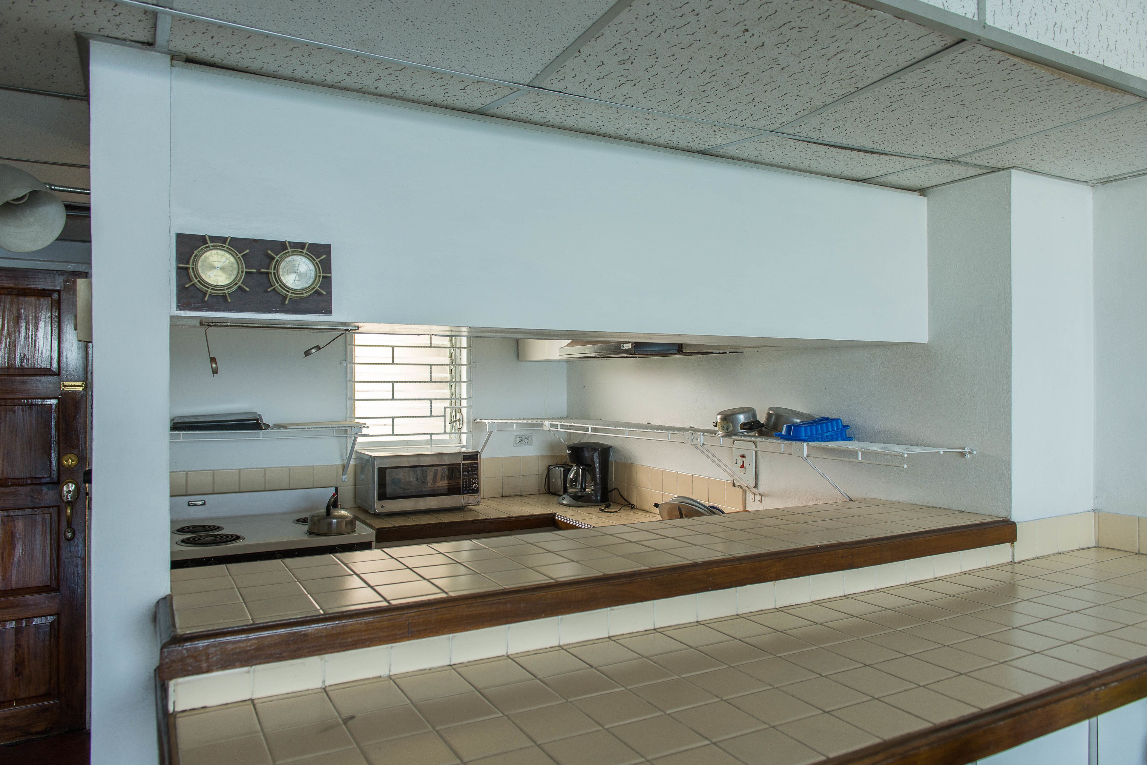 A kitchen with a microwave, stove, and coffee maker.