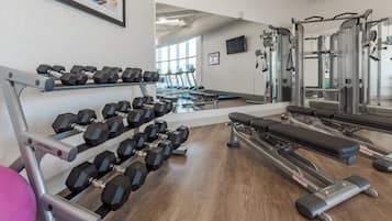 A gym with weightlifting equipment, treadmills, and exercise machines.