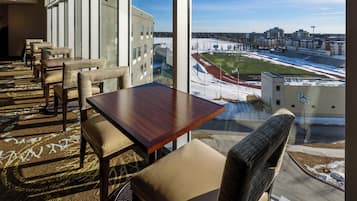 A hotel room with a large window overlooking a sports stadium and a snowy landscape.