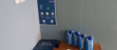 A table with water bottles, a brochure, and a poster on a wall.