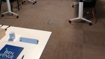 A conference room with a long table, chairs, and a podium.